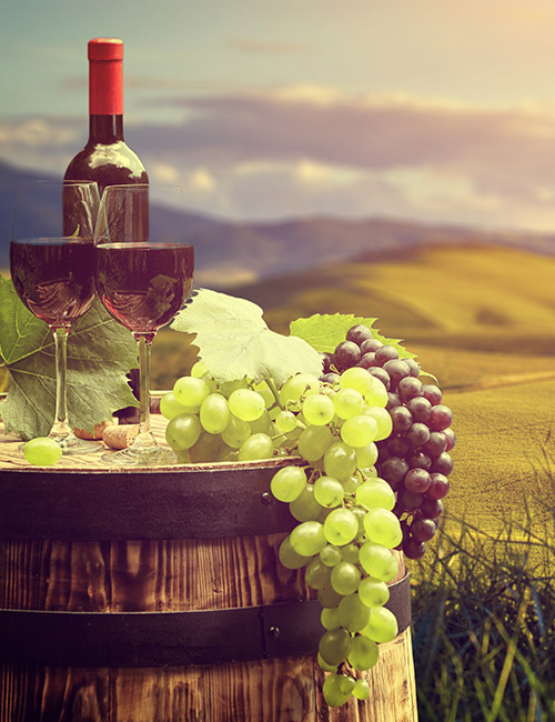 barrel with wine and grapes sitting on it